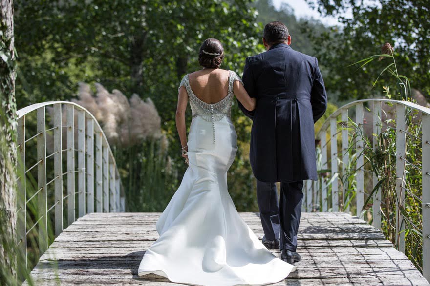 Espalda del vestido de la novia de Rosa Clará en el puente del Pazo do Tambre el día de su boda