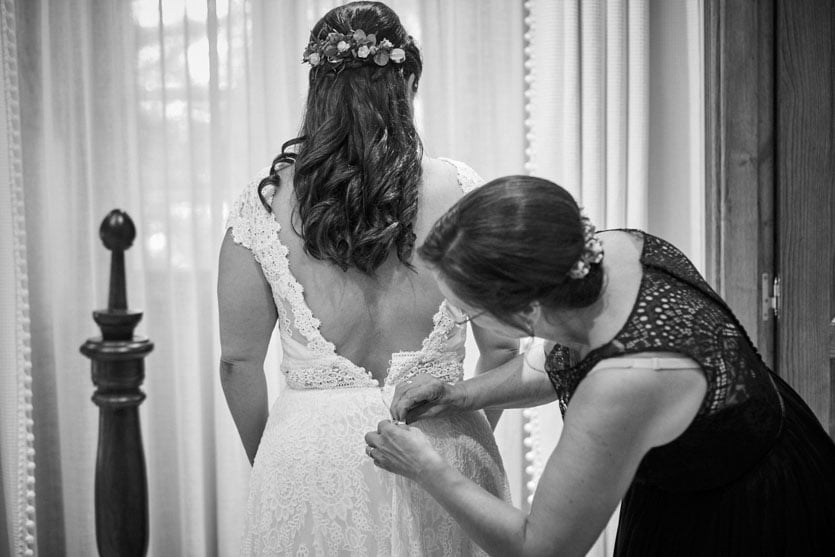 Habitación del Pazo Montesclaros, madre ayudando a poner a la novia el vestido de Pronovias